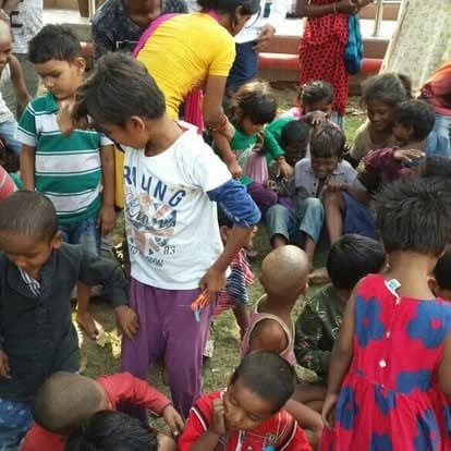 Shubhkarman volunteers with children and families at a distribution drive