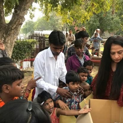 Shubhkarman volunteers with children and families at a distribution drive