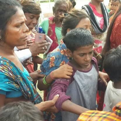 Shubhkarman volunteers with children and families at a distribution drive