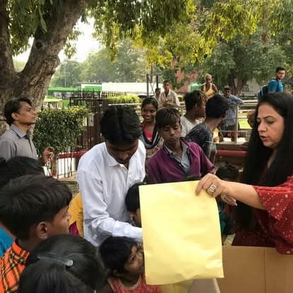 Shubhkarman volunteers with children and families at a distribution drive