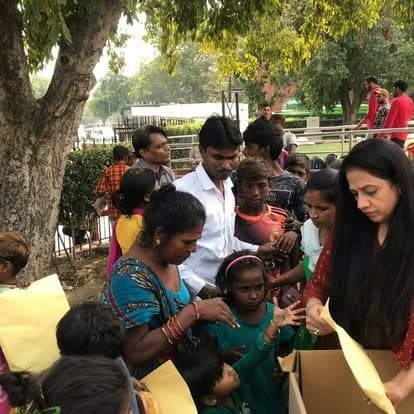 Shubhkarman volunteers with children and families at a distribution drive